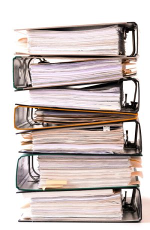 Stack of seven binders filled with papers